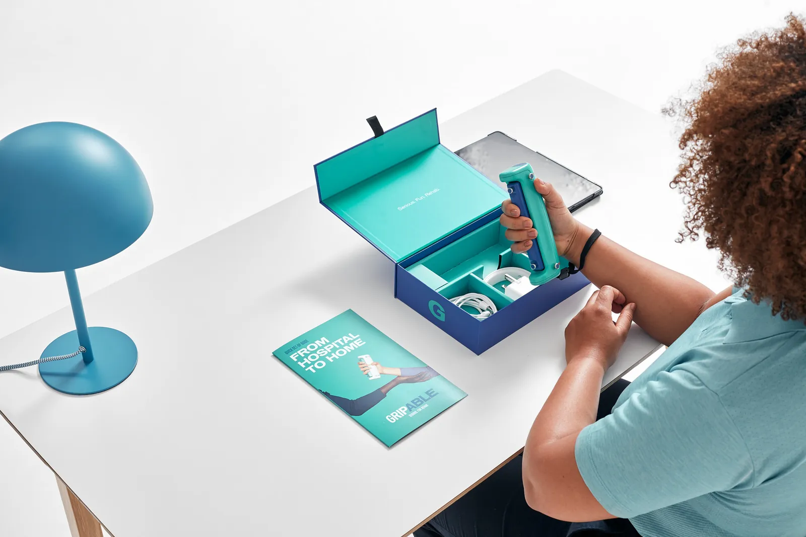 Confezione GripAble Pro aperta con dispositivo, cinghie e guida rapida